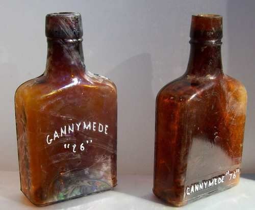 Two Different Gannymede 76 Amber Whiskey Flasks 1890s