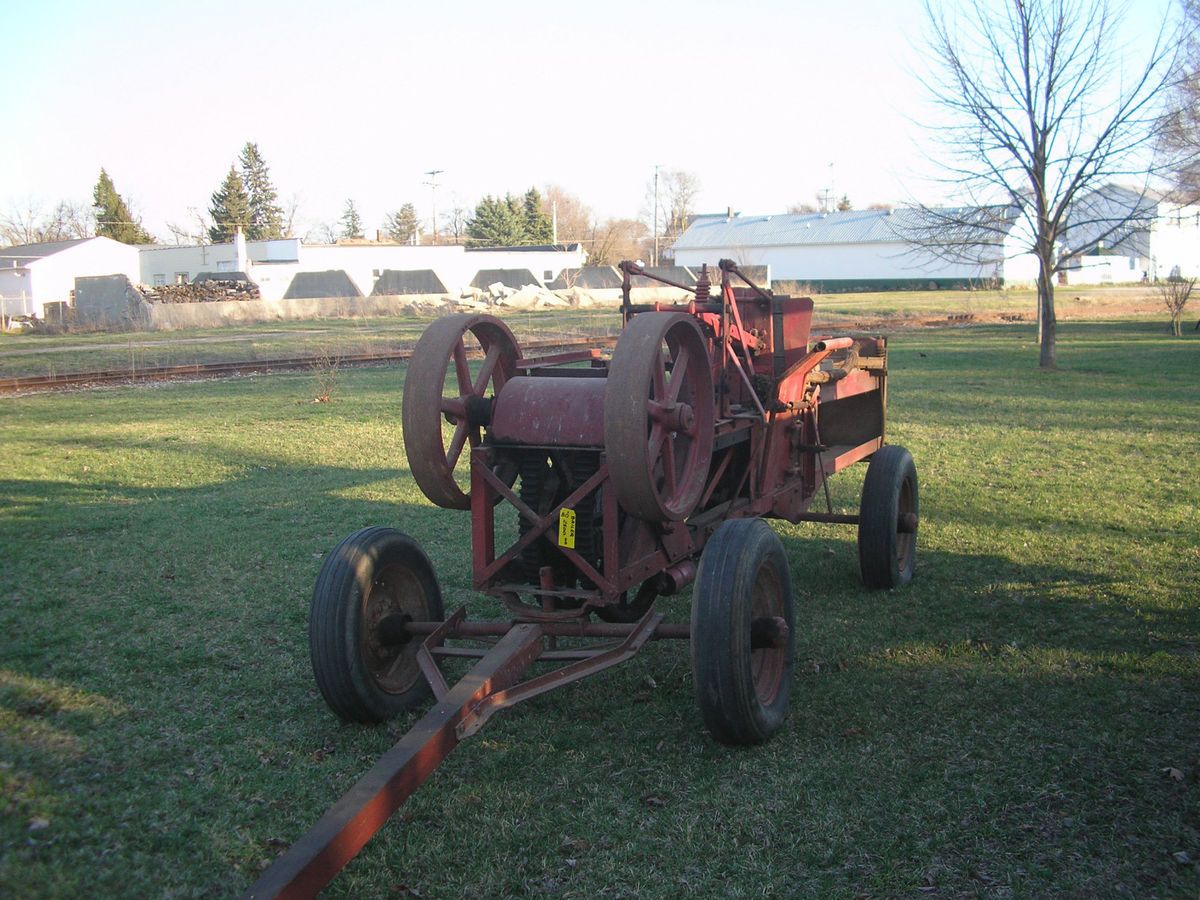 AN OLD STATIONARY HAY BAILER OR PRESS IN WORKING CONDITION WITH WIRE